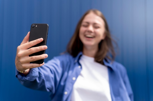 Photo femme caucasienne prenant un selfie avec son smartphone