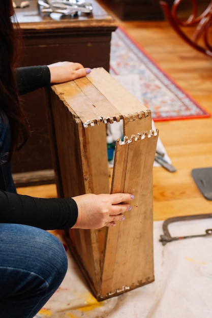 Photo femme caucasienne réparant une vieille boîte en bois en l'assemblant dans un atelier à domicile donner une nouvelle vie aux vieilles choses réutiliser les actions durables âgées pour aider la planète