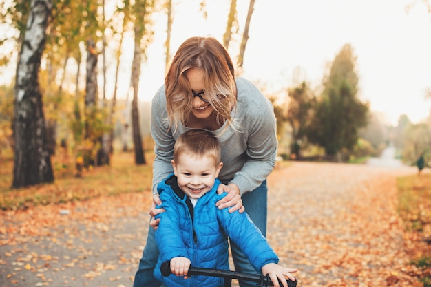 Femme caucasienne et son fils à vélo dans le parc lui apprenant