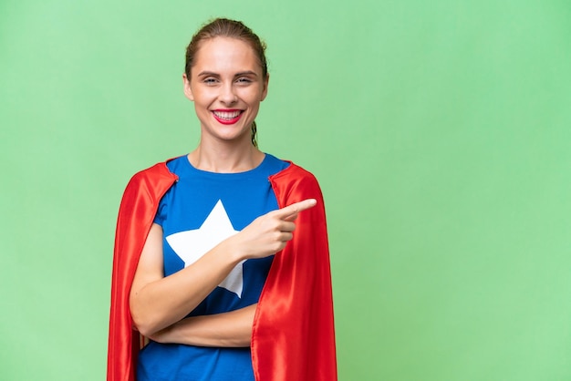 Photo femme caucasienne super héros sur fond isolé pointant vers le côté pour présenter un produit