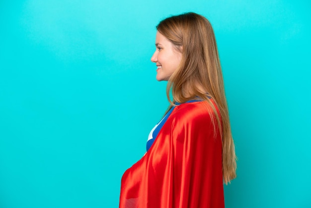 Femme caucasienne de super héros isolée sur fond bleu en position latérale