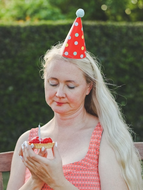 Femme célébrant son anniversaire avec un gâteau et des bougies