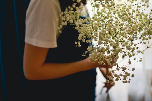 Femme célibataire tenant des fleurs blanches