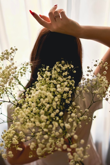 Femme célibataire tenant des fleurs blanches