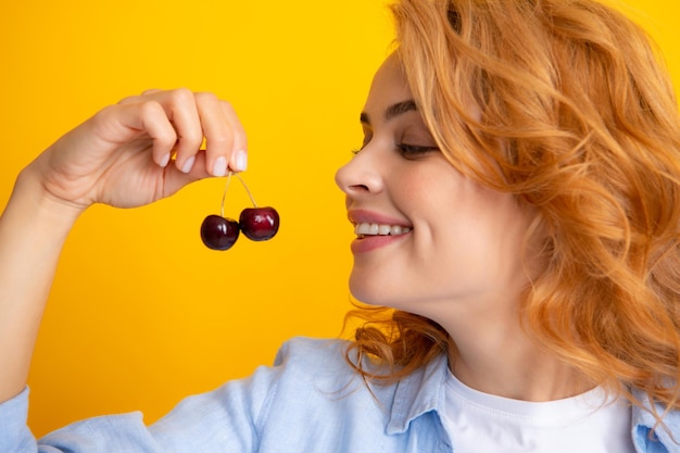 Femme avec des cerises de fruits biologiques Cerises et récolte en été Fille cueillant et mangeant des cerises mûres fruits frais Saison de récolte estivale de fruits de cerises biologiques sains