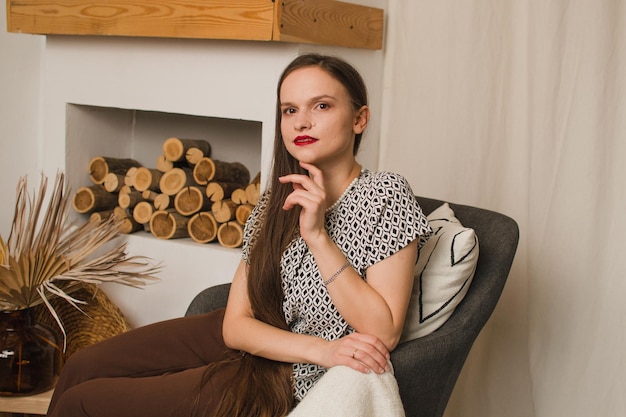 Femme sur une chaise près de la cheminée