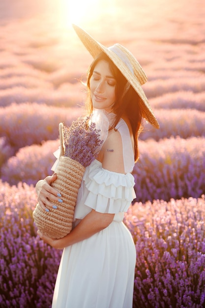 Photo femme champ de lavande jeune fille avec un panier de fleurs de lavande