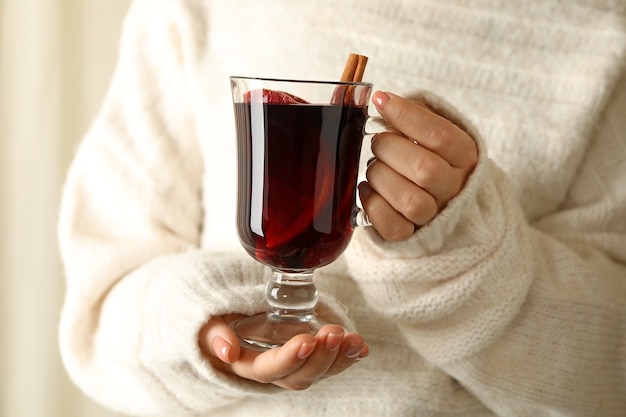 Femme en chandail tenir la tasse de vin chaud