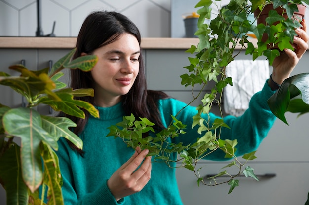 Photo femme changeant les pots de ses plantes à la maison pendant la quarantaine