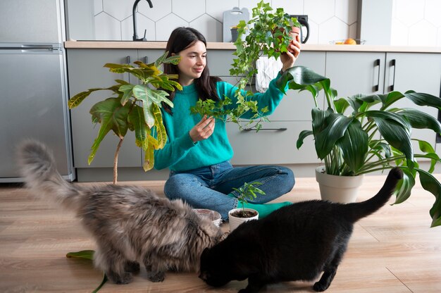 Photo femme changeant les pots de ses plantes à la maison pendant la quarantaine