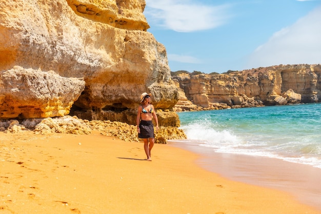 Une femme avec un chapeau en Algarve sur la plage de Praia da Coelha Albufeira Portugal