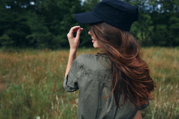 Femme avec un chapeau et des cheveux longs chemise verte forêt naturelle