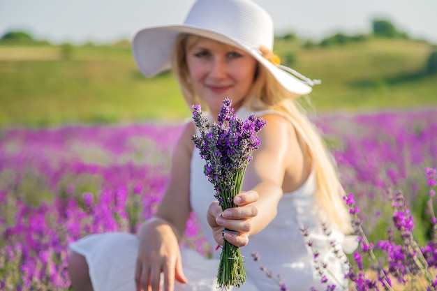 Femme avec chapeau dans le champ de lavande. Mise au point sélective.