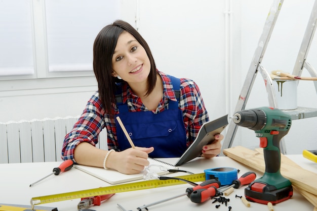 Femme charpentier assis au bureau dans son atelier