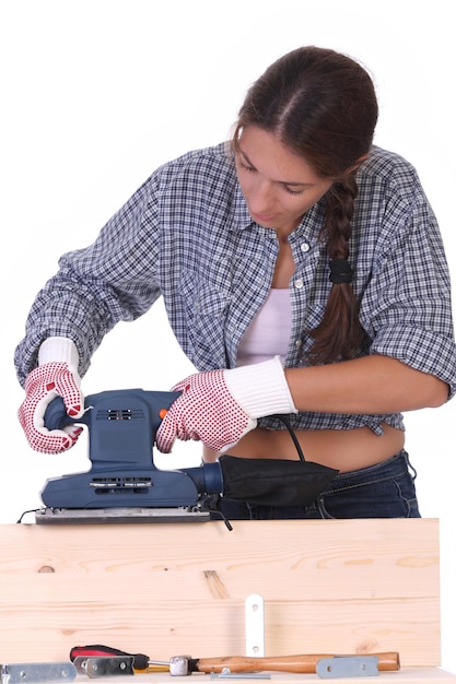 Femme charpentier au travail ponceuse