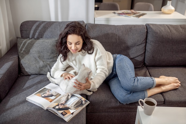 Photo une femme avec un chat. jeune femme aux cheveux noirs avec un joli chat blanc