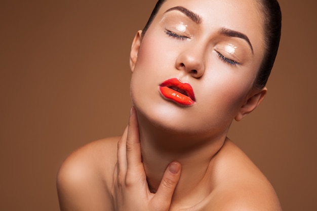 Femme chaude avec maquillage humide sur mur marron