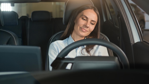 Une femme chauffeur blanche heureuse, une cliente, une acheteuse, une fille assise dans une voiture, un véhicule de transport confortable.