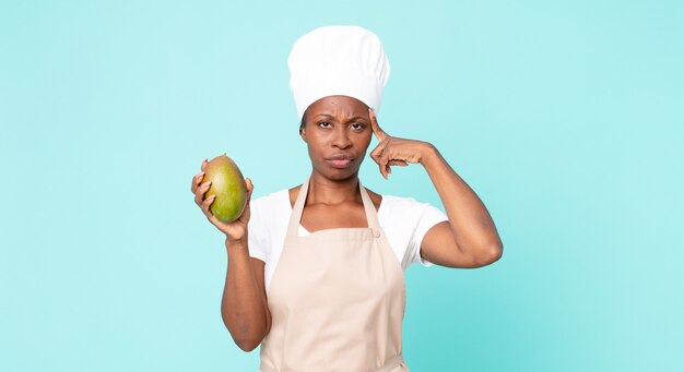 Femme de chef adulte afro-américaine noire hwith une mangue