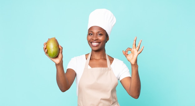 Femme de chef adulte afro-américaine noire hwith une mangue