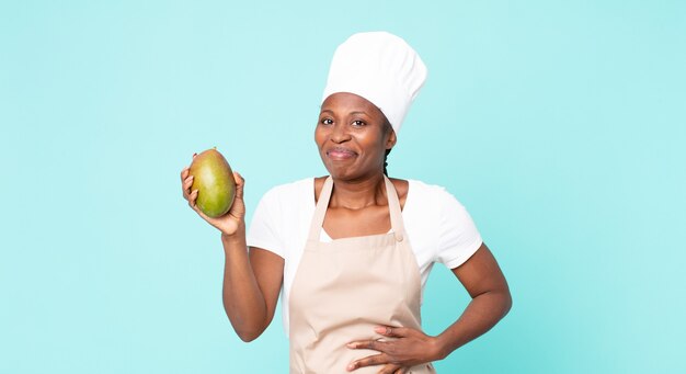 Femme de chef adulte afro-américaine noire hwith une mangue