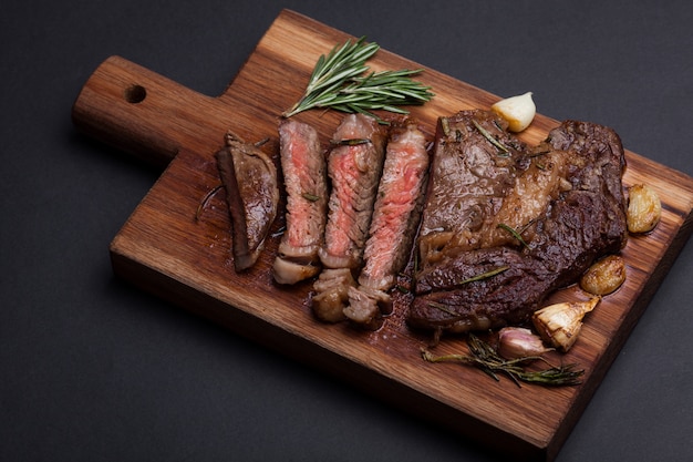 La femme chef prépare un steak de bœuf.