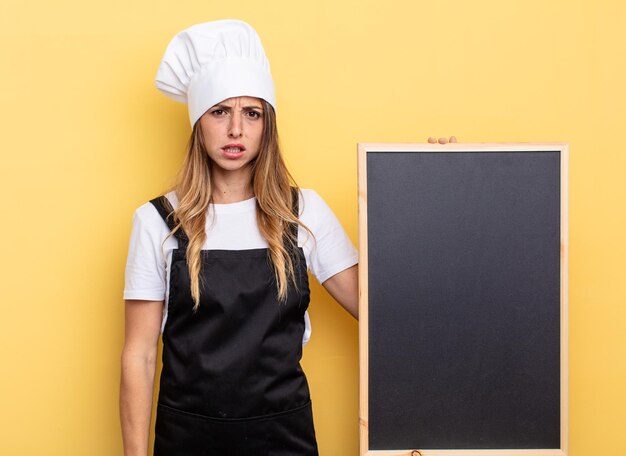 femme chef se sentant perplexe et confuse. concept de menu tableau noir