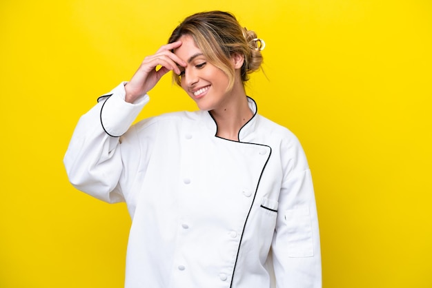 Femme chef uruguayenne isolée sur fond jaune en riant