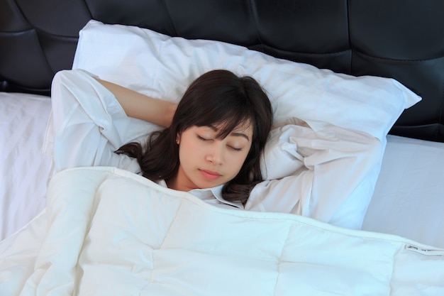 femme en chemise blanche, dormant dans sa chambre. concept pour la santé.