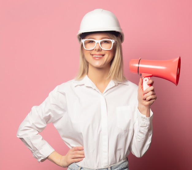 Femme en chemise blanche, lunettes et casque avec haut-parleur