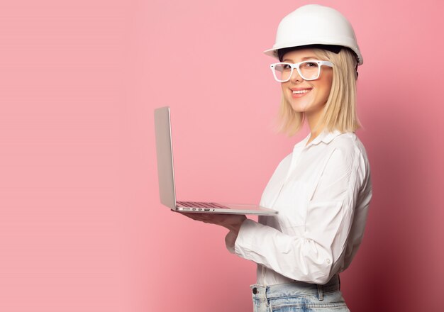 Femme en chemise blanche, lunettes et casque avec ordinateur portable