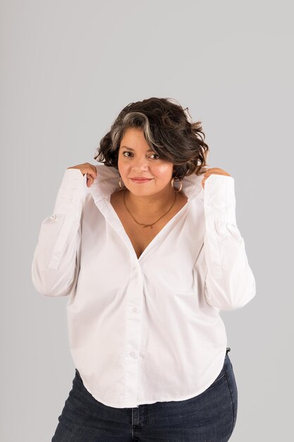 Une femme en chemise blanche pose pour une photo.