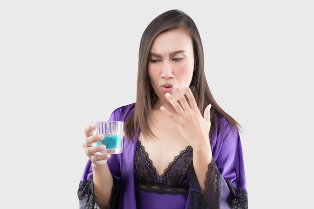 Photo une femme en chemise de nuit violette se sent brûlée dans la bouche parce qu'elle utilise du rince-bouche