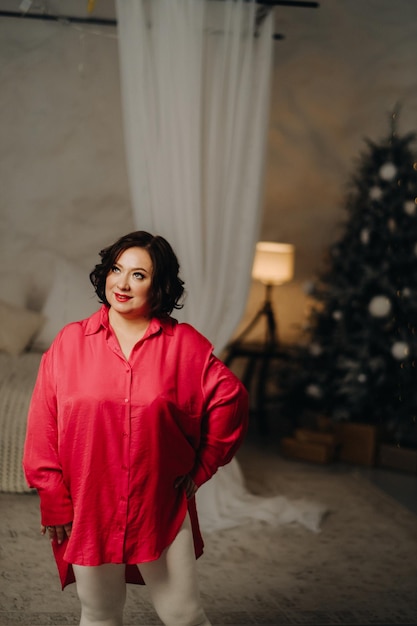 Une femme en chemise rouge dans une salle décorée pour l'ambiance de Noël Accueil Nouvel An