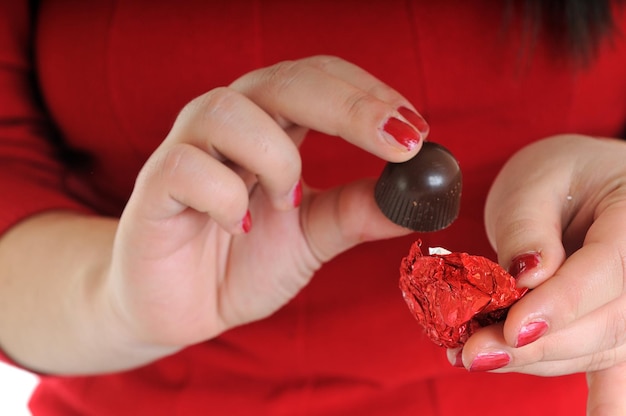 femme en chemise rouge manger des aliments sucrés au chocolat