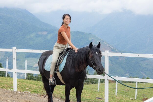 Une femme à cheval dans la ferme