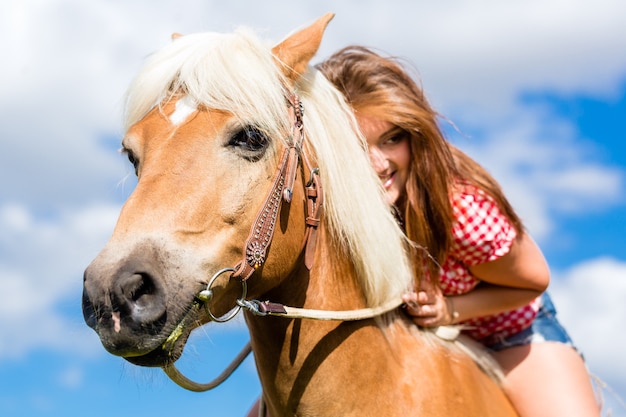 Femme à cheval dans la prairie d'été