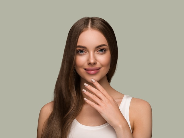 Femme de cheveux longs en bonne santé avec portrait de visage de peau de beauté cheveux longs bouclés. Couleur de fond vert