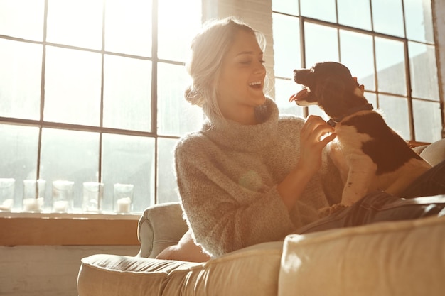 Femme chien et sur canapé dans le salon bonheur et soleil avec fille bonheur et liaison à la maison