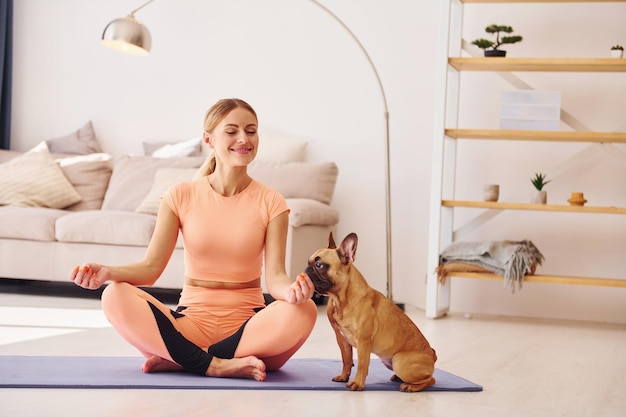 Une femme avec un chien carlin est à la maison pendant la journée