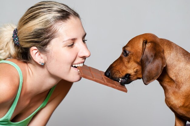 Femme avec un chien dans une lutte pour le chocolat