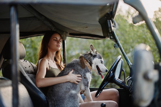 Femme et chien husky voyageant joyeusement en voiture sourire avec des dents tombent à pied avec un animal de compagnie voyage avec un ami chien câlins et danses