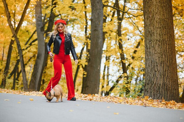 Femme avec chien marchant dans le parc