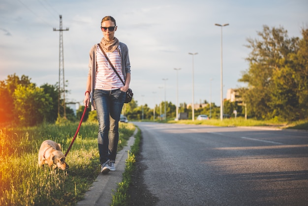 Femme et chien marchant sur la route