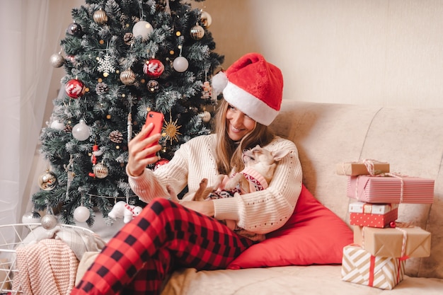 Femme et chien en pull s'amusant prend portrait de selfie