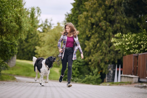 Femme avec un chien qui promène dans le parc