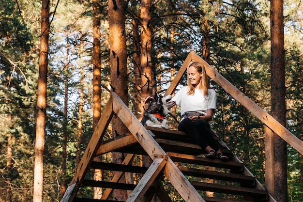 Une femme et un chien se regardent sourire et sont heureux