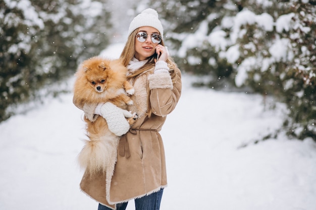 Femme avec chien et téléphone en hiver