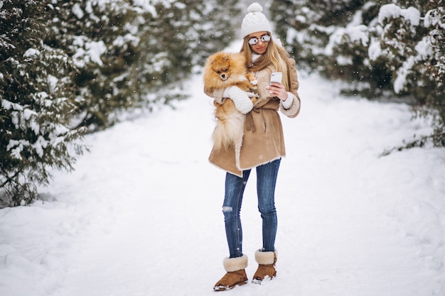 Femme avec chien et téléphone en hiver