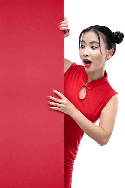 Femme chinoise asiatique dans une robe cheongsam debout derrière un mur vide